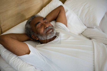 Téléchargez les photos : Homme âgé dormant sur le lit dans la chambre - en image libre de droit
