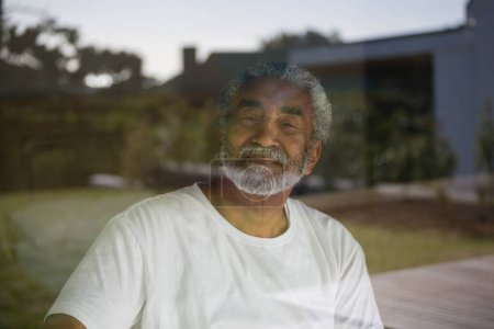 Téléchargez les photos : Homme âgé souriant relaxant à la maison - en image libre de droit