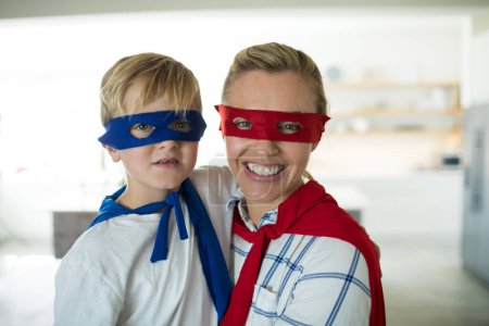 Téléchargez les photos : Portrait de mère et fils se faisant passer pour un super-héros dans le salon - en image libre de droit
