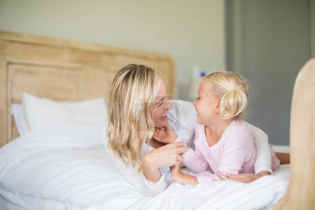 Photo for Mother and daughter having fun in the bedroom - Royalty Free Image
