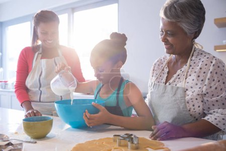 Téléchargez les photos : Bonne famille multi-génération faire des biscuits dans la cuisine - en image libre de droit