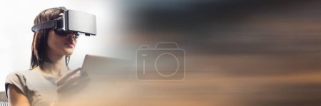 Photo for Business woman with tablet and virtual reality headset with blurry sunset transition - Royalty Free Image