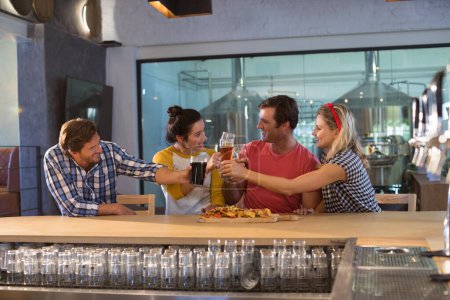 Téléchargez les photos : Happy friends toasting drinks au comptoir du bar - en image libre de droit