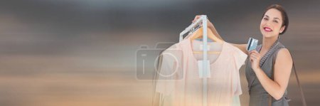 Photo for Woman shopping with clothes rack and credit card - Royalty Free Image