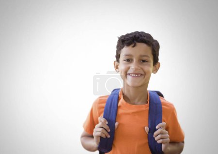 Photo for Schoolboy holding bag with grey background - Royalty Free Image