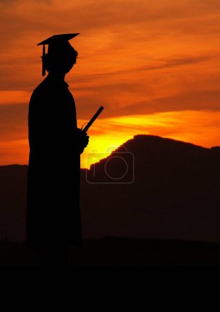 Photo for Graduate student holding his diploma against sunset or sunrise - Royalty Free Image