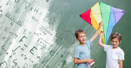 Foto de Niños sosteniendo cometa con ecuaciones matemáticas en pizarra - Imagen libre de derechos