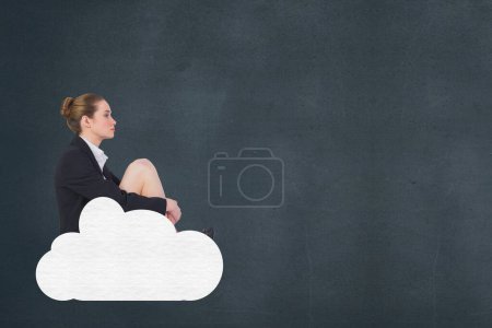 Photo for Business woman sitting on a cloud against blue background - Royalty Free Image