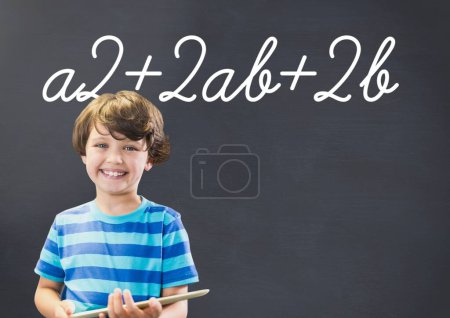 Photo for Boy on tablet with math writing on blackboard - Royalty Free Image