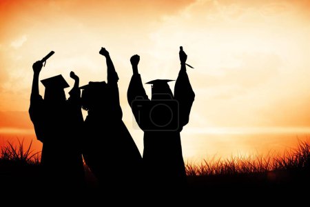 Photo for Graduate students raising their diplomas against sunset or sunrise - Royalty Free Image