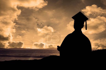 Photo for A graduate student holding his diploma against sunset or sunrise - Royalty Free Image