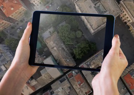 Téléchargez les photos : Tenir la tablette au-dessus de la ville vue aérienne - en image libre de droit
