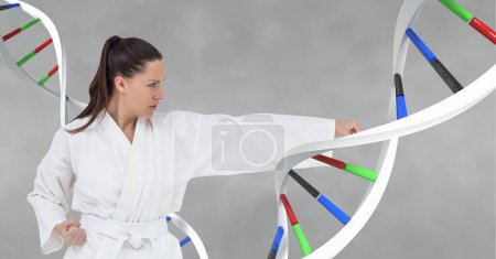 Foto de Mujer haciendo artes marciales con hebra de ADN 3D sobre fondo gris - Imagen libre de derechos