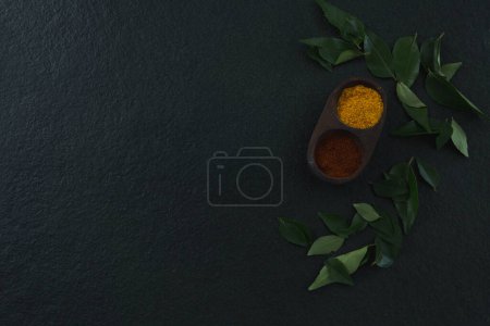 Téléchargez les photos : Poudre d'épices dans un bol avec feuille de curry - en image libre de droit