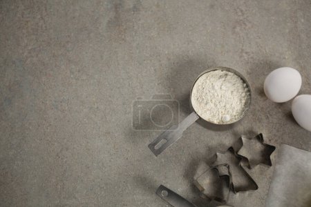 Foto de Vista aérea de la harina en taza medidora por moldes y huevo - Imagen libre de derechos