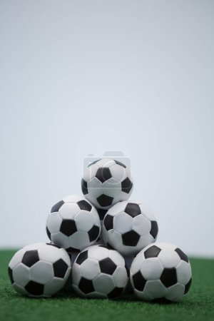 Téléchargez les photos : Empilement de balles de football empilées sur gazon artificiel - en image libre de droit