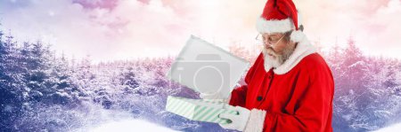 Photo for Santa with Winter landscape and gift - Royalty Free Image