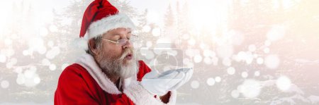 Photo for Santa with Winter landscape blowing hands - Royalty Free Image