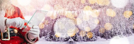 Téléchargez les photos : Santa avec paysage d'hiver avec tablette en verre - en image libre de droit