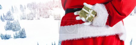 Photo for Santa with Winter landscape holding gift - Royalty Free Image