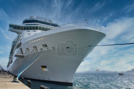 Foto de Enorme crucero blanco atado a bolardo en muelle - Imagen libre de derechos