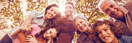 Téléchargez les photos : Joyeux famille souriant dans le parc - en image libre de droit
