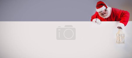 Foto de Santa Claus sosteniendo linterna de Navidad en pizarra blanca - Imagen libre de derechos