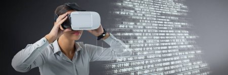 Photo for Composite image of female executive using virtual reality headset - Royalty Free Image