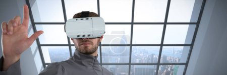 Téléchargez les photos : Image composite d'un geste de l'homme en utilisant un casque de réalité virtuelle - en image libre de droit