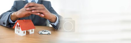 Photo for House model and car under businessman's protective hands - Royalty Free Image