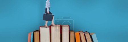 Photo for Business woman climbing books with blue background - Royalty Free Image