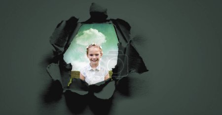 Téléchargez les photos : Fille enfant heureux regardant à travers le trou surréaliste dans le papier - en image libre de droit
