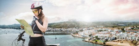Téléchargez les photos : Femme voyageuse avec vélo et carte en face du paysage de la ville côtière - en image libre de droit