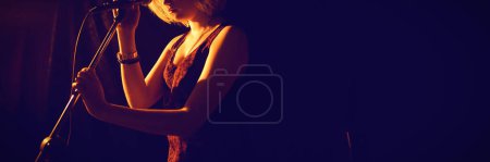 Photo for Thoughtful woman with microphone at club - Royalty Free Image