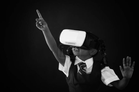 Téléchargez les photos : Écolière utilisant casque de réalité virtuelle contre tableau noir - en image libre de droit