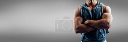 Photo for Strong man crossing arms on grey background - Royalty Free Image