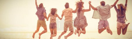 Photo for Happy friends holding hands and jumping - Royalty Free Image
