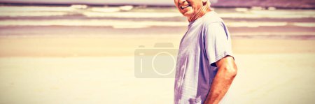 Téléchargez les photos : Portrait d'un homme âgé debout à la plage - en image libre de droit