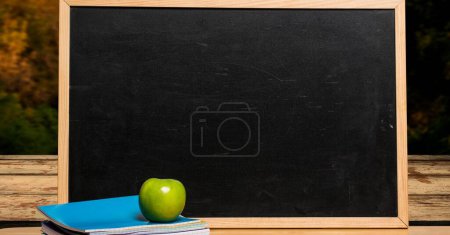 Photo for Autumn trees and education blackboard with apple on wood surface - Royalty Free Image