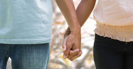 Téléchargez les photos : Couple d'automne tenant la main avec un ciel lumineux - en image libre de droit