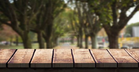 Foto de Árboles otoñales con superficie de madera en primer plano - Imagen libre de derechos