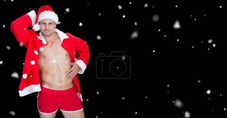 Photo for Fit sexy Santa man with snow falling - Royalty Free Image