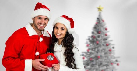 Téléchargez les photos : Couple d'hiver de Noël avec arbre de Noël et cadeau - en image libre de droit