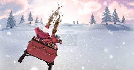 Foto de Santa volando en trineo con renos sobre el paisaje invernal - Imagen libre de derechos