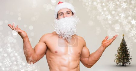 Photo for Fit sexy Santa man with snowflakes and Christmas tree - Royalty Free Image