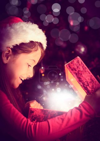 Foto de Chica excitada abriendo mágica caja de regalo de Navidad con luz brillante - Imagen libre de derechos