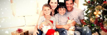 Téléchargez les photos : Image composite de la famille heureuse à Noël tenant beaucoup de cadeaux - en image libre de droit