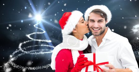 Téléchargez les photos : Couple avec cadeau et sapin de Noël rayonnant - en image libre de droit