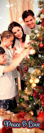 Foto de Imagen compuesta de familia feliz decorando un árbol de navidad con adornos - Imagen libre de derechos