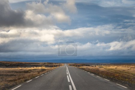 Photo for "Empty road in Iceland driving in sunshine towards bad weather in the Highlands" - Royalty Free Image